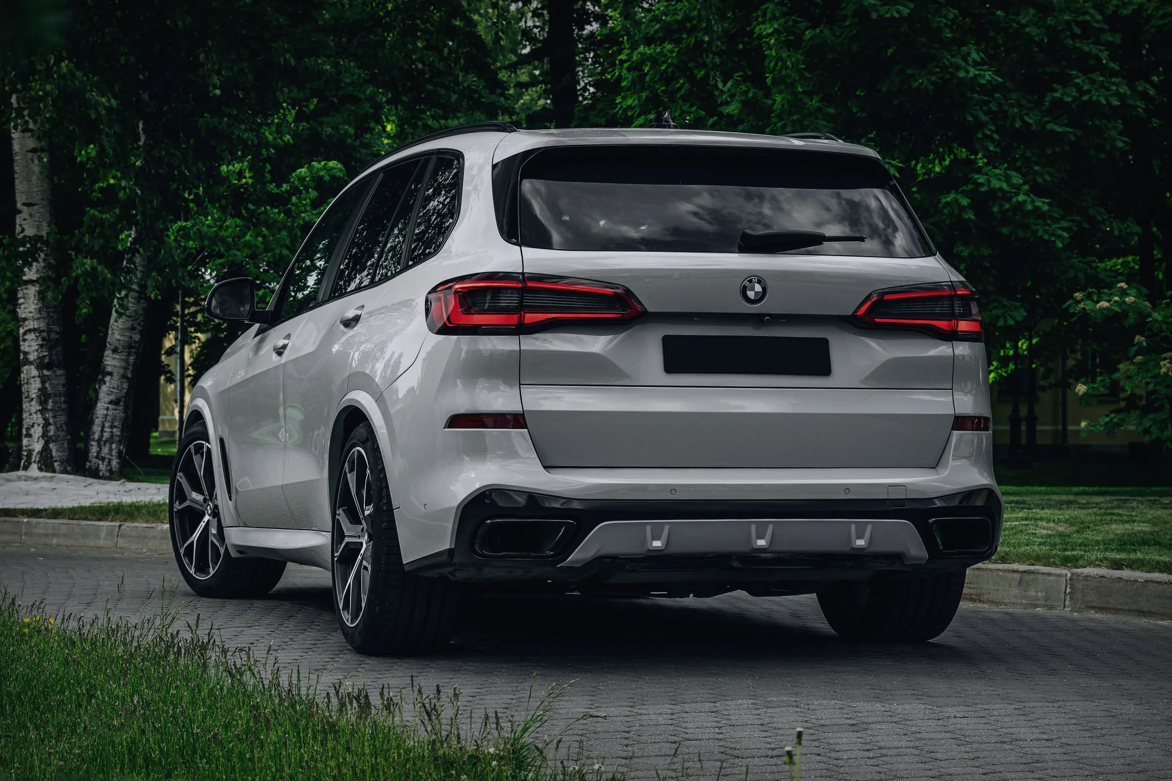 Истиот бел BMW X5 гледан одзади и од страна.