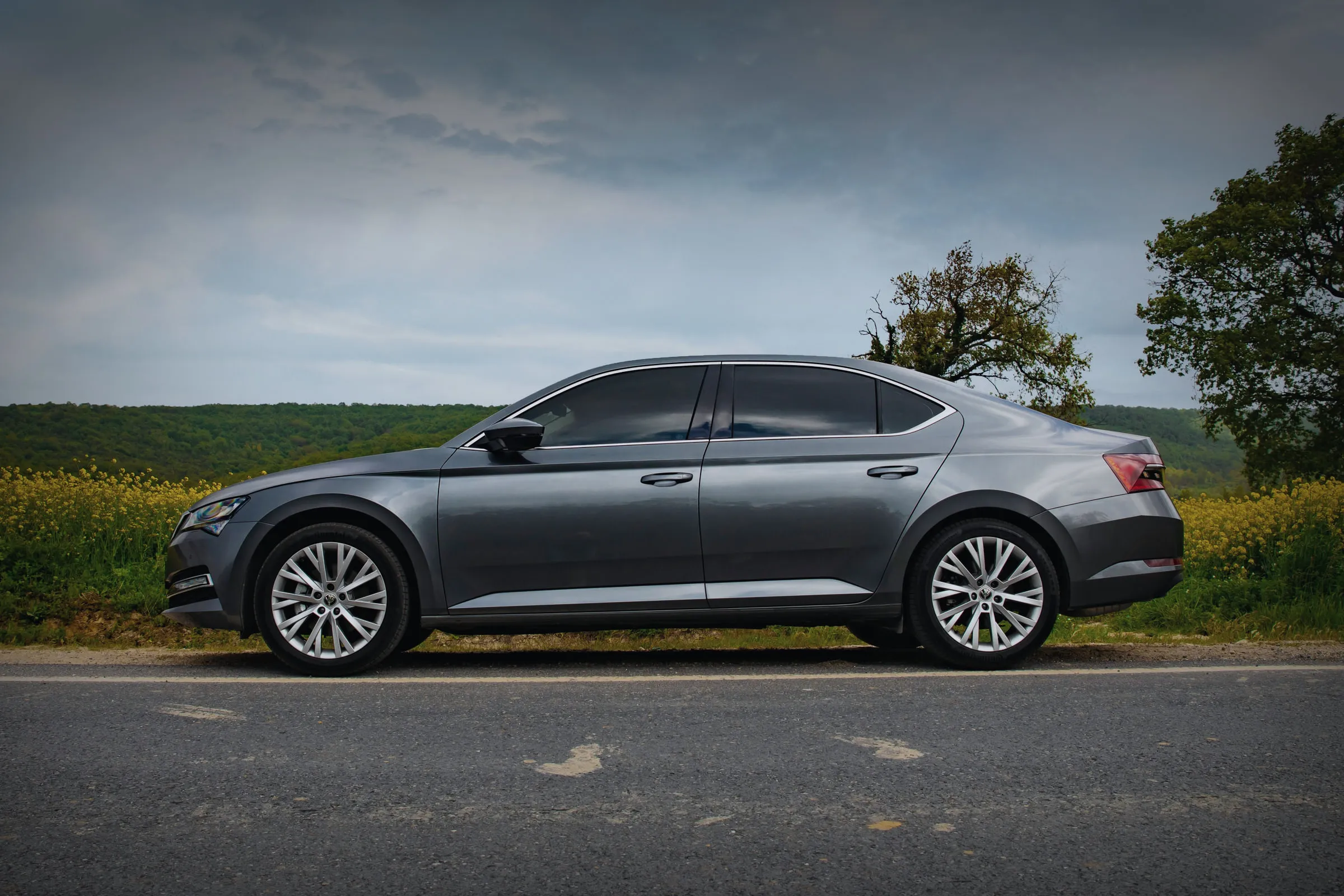 Истата Škoda Superb од страна, на селски пат.
